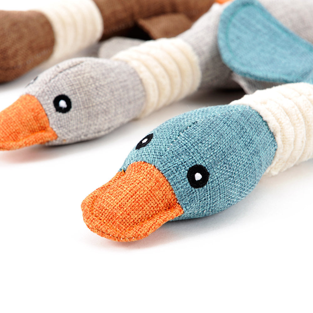 Close-up of plush goose dog toy faces