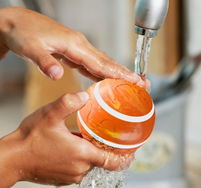 Washable rolling cat ball under a tap